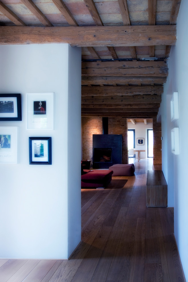 Modern inredning av ett mellanstort allrum med öppen planlösning, med ett finrum, grå väggar, mellanmörkt trägolv och en väggmonterad TV