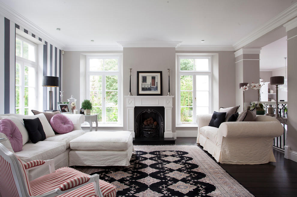 Design ideas for a classic living room in London with grey walls, dark hardwood flooring and a standard fireplace.