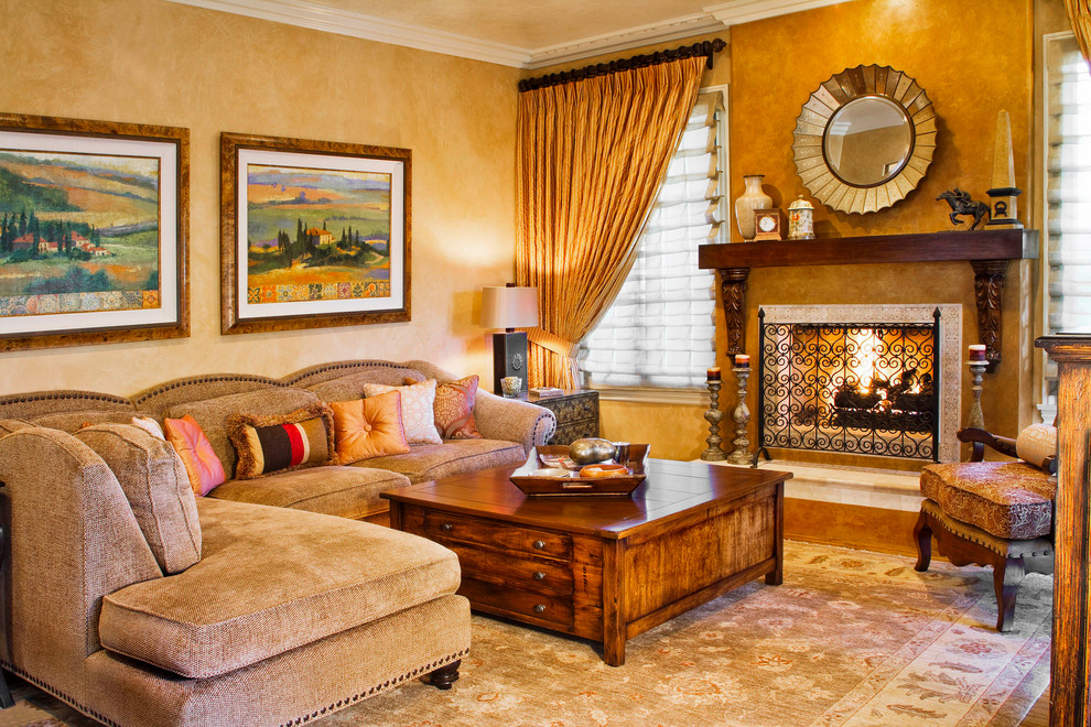 Exemple d'un salon méditerranéen fermé avec une cheminée standard, un mur beige, parquet clair, un manteau de cheminée en plâtre, aucun téléviseur, un sol marron et éclairage.