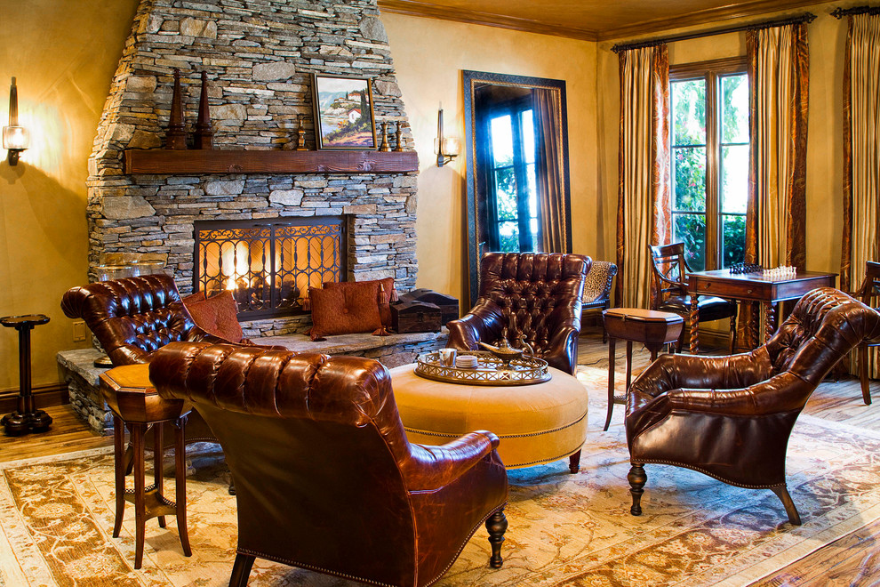 This is an example of a mediterranean enclosed living room in Los Angeles with a stone fireplace surround, beige walls, light hardwood flooring, a standard fireplace, no tv and brown floors.