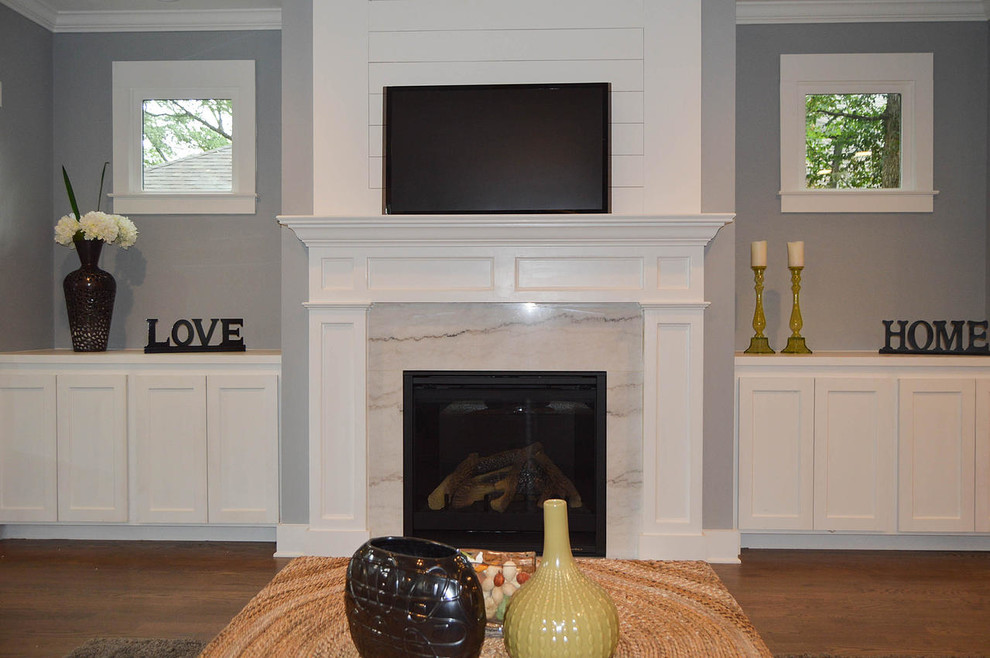 アトランタにある高級な広いトランジショナルスタイルのおしゃれなリビング (グレーの壁、淡色無垢フローリング、標準型暖炉、壁掛け型テレビ、石材の暖炉まわり、茶色い床) の写真