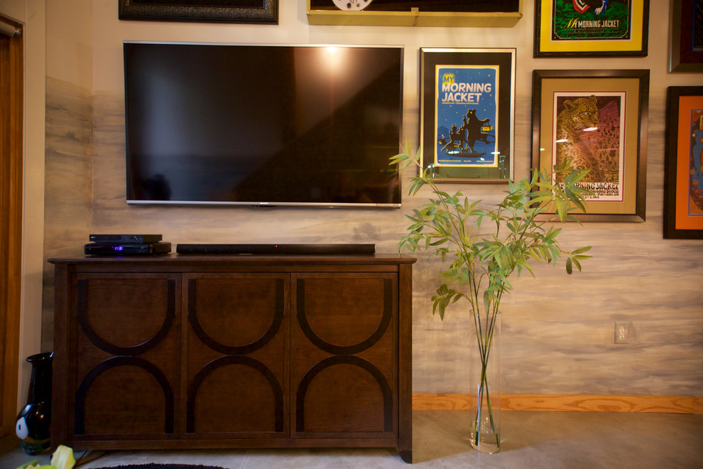 Ejemplo de salón abierto clásico renovado de tamaño medio sin chimenea con paredes grises, suelo de cemento, televisor colgado en la pared y suelo marrón