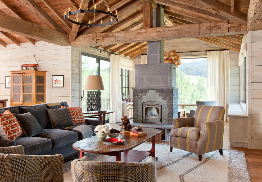 Example of a mountain style open concept living room design in Other with a wood stove