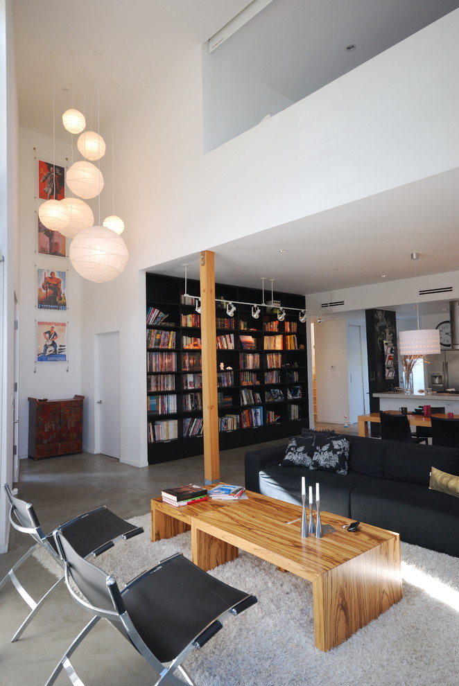 Imagen de biblioteca en casa abierta moderna con suelo de cemento, paredes blancas, todas las chimeneas y marco de chimenea de baldosas y/o azulejos