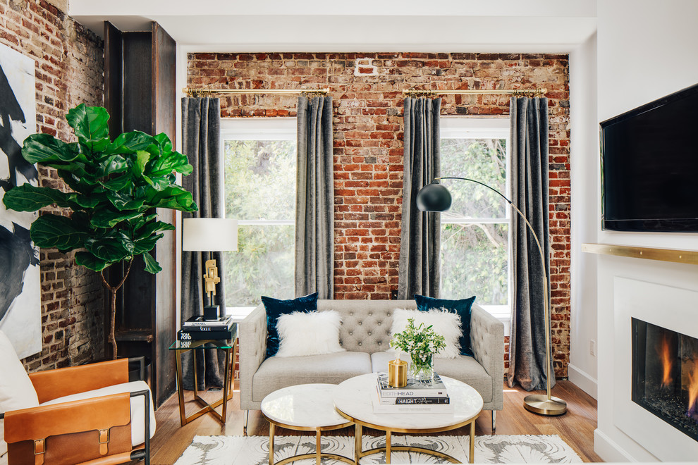 Example of a small minimalist loft-style medium tone wood floor living room design in San Francisco with white walls and a standard fireplace