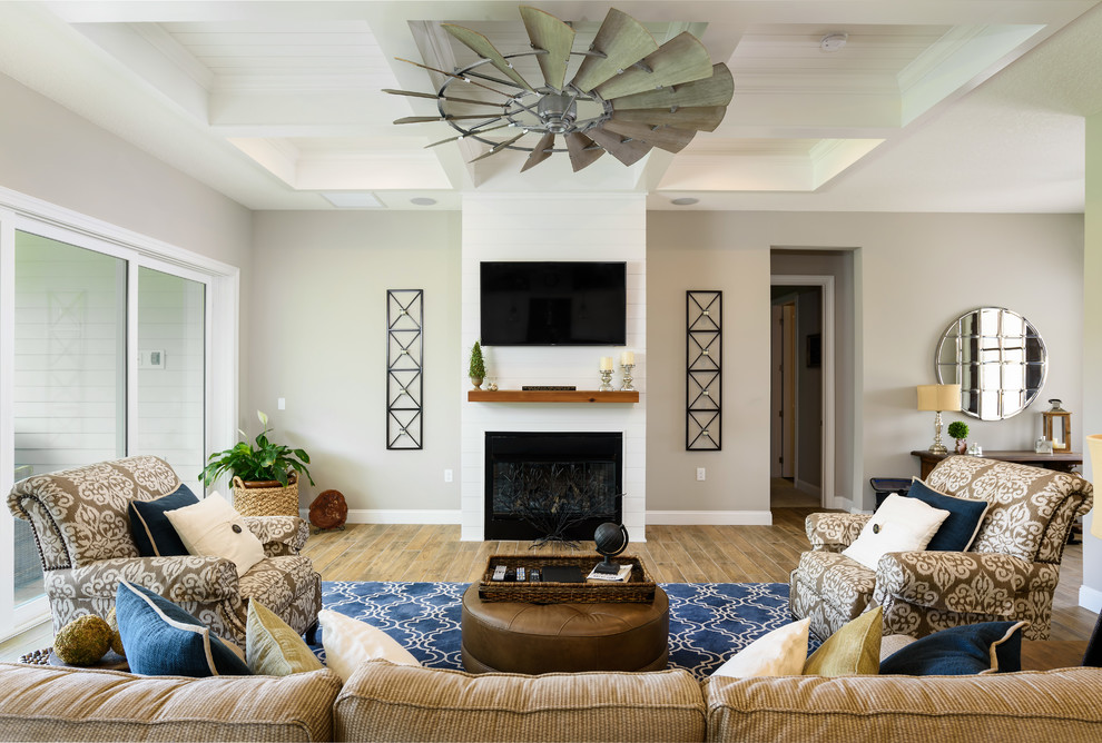 ジャクソンビルにあるお手頃価格の中くらいなトラディショナルスタイルのおしゃれなリビング (ベージュの壁、セラミックタイルの床、標準型暖炉、木材の暖炉まわり、壁掛け型テレビ、マルチカラーの床) の写真