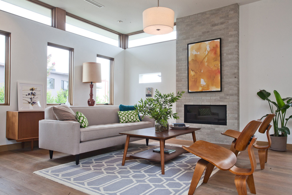 Medium sized retro open plan living room in Los Angeles with white walls, medium hardwood flooring, a standard fireplace and a brick fireplace surround.