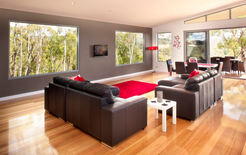 Großes, Offenes Modernes Wohnzimmer mit grauer Wandfarbe, hellem Holzboden und TV-Wand in Hobart