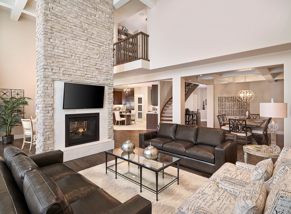Traditional formal living room in Edmonton with a two-sided fireplace, a wall mounted tv and brown floors.
