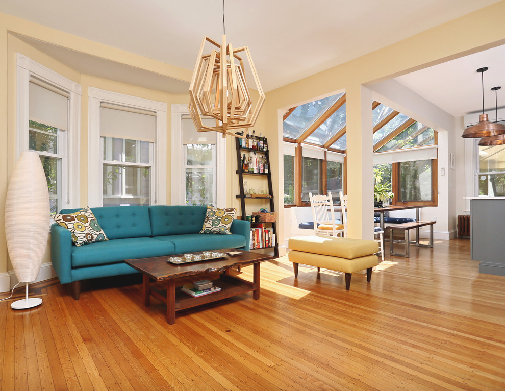 Esempio di un piccolo soggiorno tradizionale aperto con pareti gialle e pavimento in legno massello medio