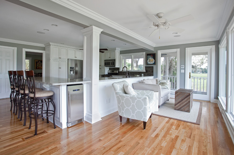 Example of a large island style open concept light wood floor living room design in Charleston