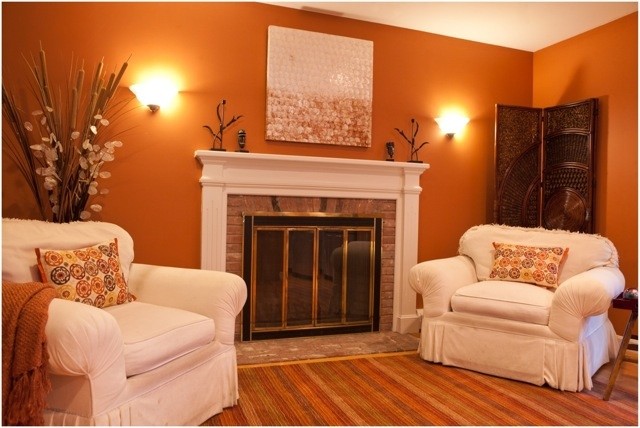 Inspiration för mellanstora klassiska separata vardagsrum, med ett finrum, orange väggar, mellanmörkt trägolv, en standard öppen spis, en spiselkrans i tegelsten och brunt golv