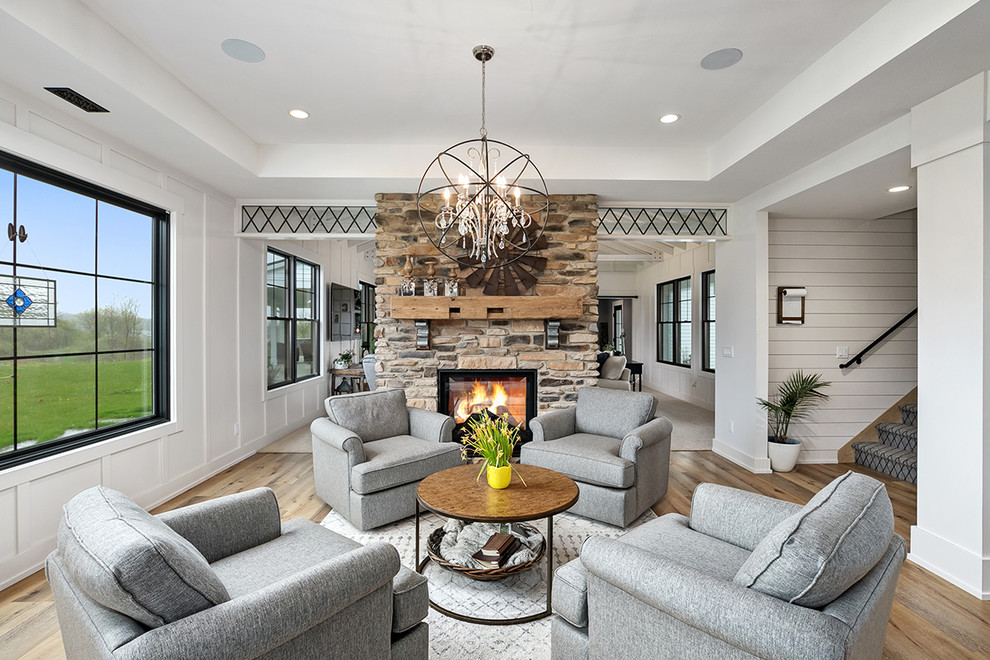Example of a cottage open concept and formal brown floor living room design in Grand Rapids with white walls, a stone fireplace and a standard fireplace