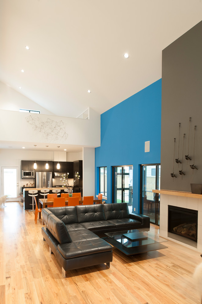 Idées déco pour un salon contemporain de taille moyenne et ouvert avec un mur bleu, parquet clair, une cheminée standard et un manteau de cheminée en carrelage.