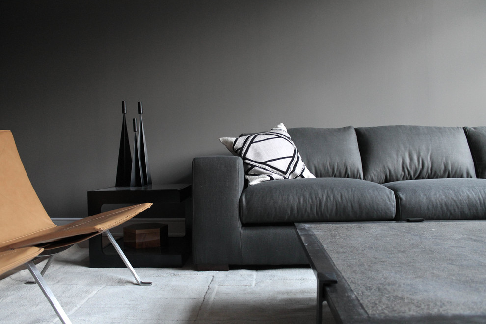 Foto de salón abierto actual con paredes grises, suelo de madera clara y televisor independiente