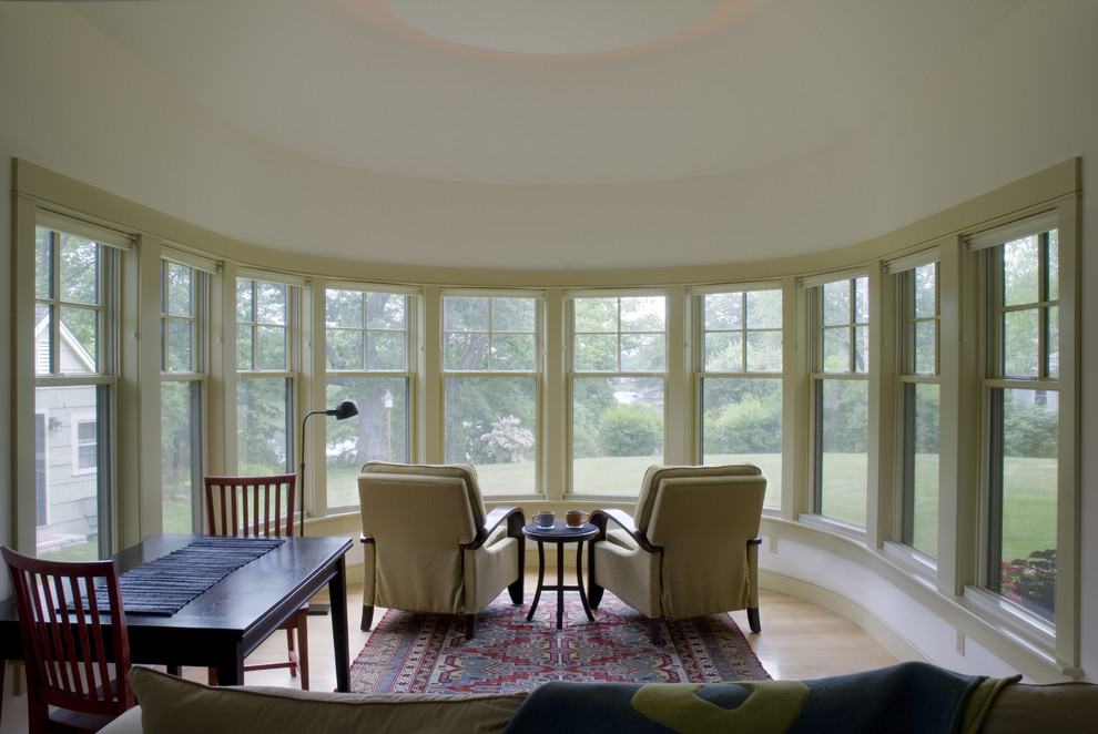 Photo of a large traditional living room in Portland Maine with grey walls and light hardwood flooring.