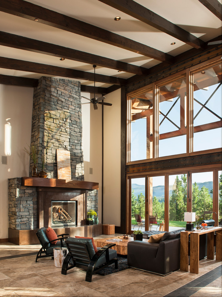 Design ideas for a rustic open plan living room in Seattle with beige walls, a standard fireplace, a stone fireplace surround and feature lighting.