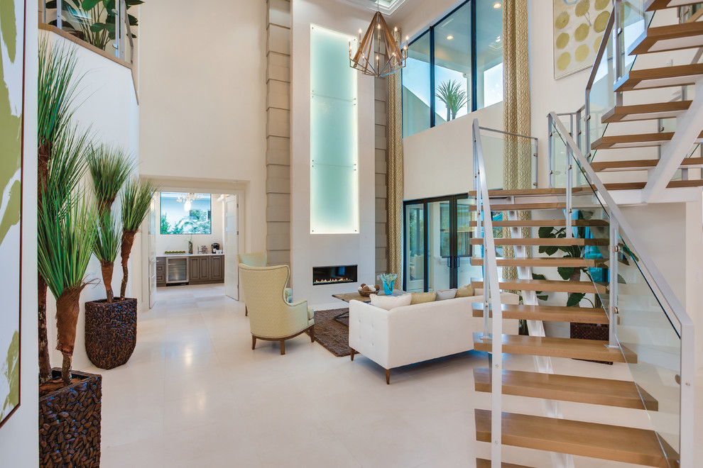 Идея дизайна: парадная, двухуровневая гостиная комната с белыми стенами, полом из известняка, горизонтальным камином и фасадом камина из камня без телевизора