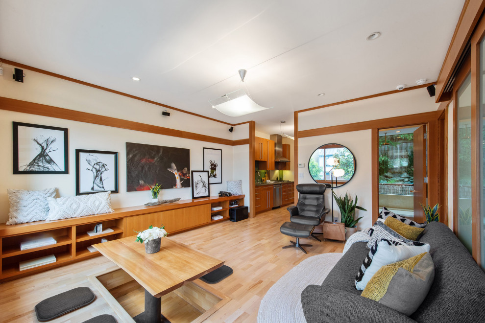 Modelo de salón abierto de estilo zen pequeño con paredes blancas, suelo de madera clara, suelo beige y madera