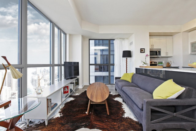 Kleines, Offenes Modernes Wohnzimmer ohne Kamin mit weißer Wandfarbe, hellem Holzboden, freistehendem TV und grauem Boden