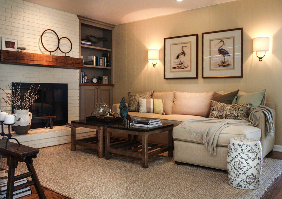 Example of a classic open concept medium tone wood floor living room design in Denver with beige walls, a standard fireplace, a brick fireplace and a media wall