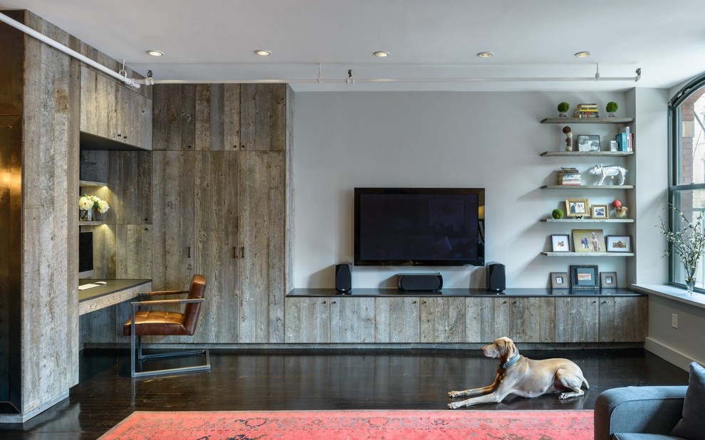 Diseño de salón urbano de tamaño medio sin chimenea con paredes grises, suelo de madera oscura, televisor colgado en la pared y suelo marrón