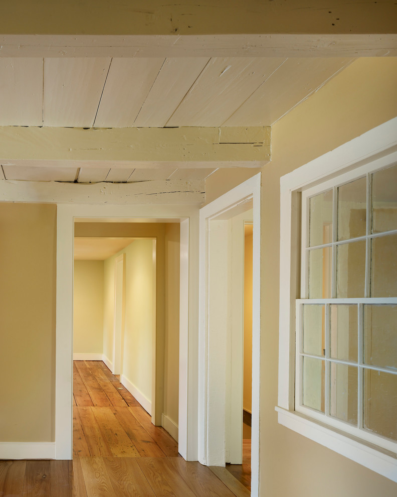 На фото: гостиная комната среднего размера в классическом стиле с желтыми стенами, паркетным полом среднего тона, стандартным камином, фасадом камина из дерева и коричневым полом
