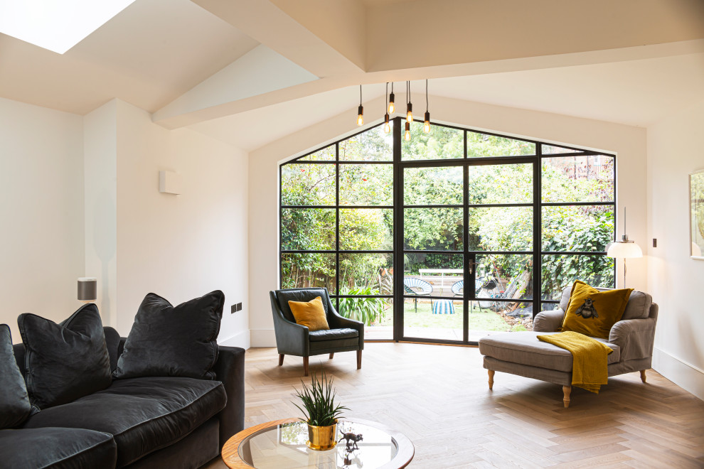 Diseño de salón abierto clásico renovado grande con paredes blancas, suelo de madera clara y suelo beige