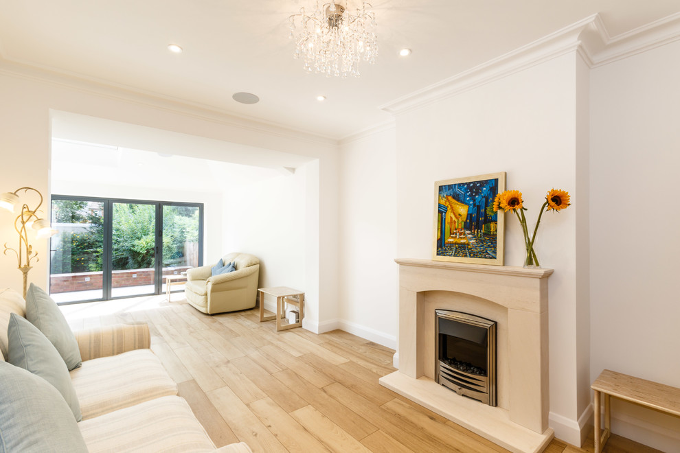 This is an example of a contemporary living room in London with light hardwood flooring, a standard fireplace and a concrete fireplace surround.
