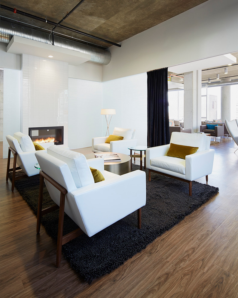 Offenes Modernes Wohnzimmer mit weißer Wandfarbe, dunklem Holzboden, Kamin und gefliester Kaminumrandung in Chicago