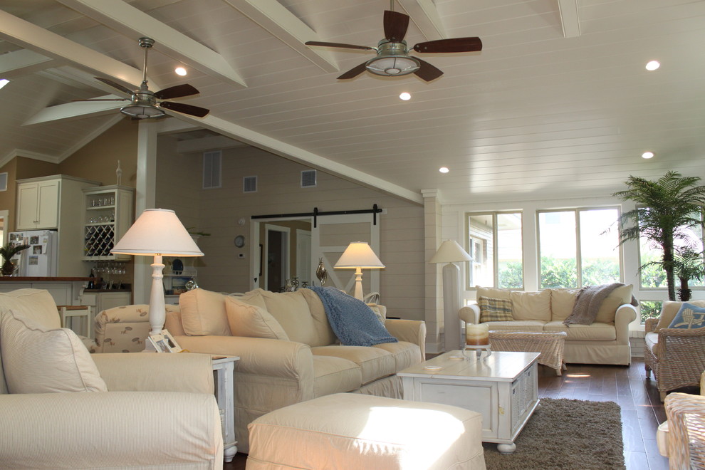 This is an example of a large world-inspired open plan living room in Jacksonville with white walls, medium hardwood flooring, a standard fireplace, a brick fireplace surround and brown floors.