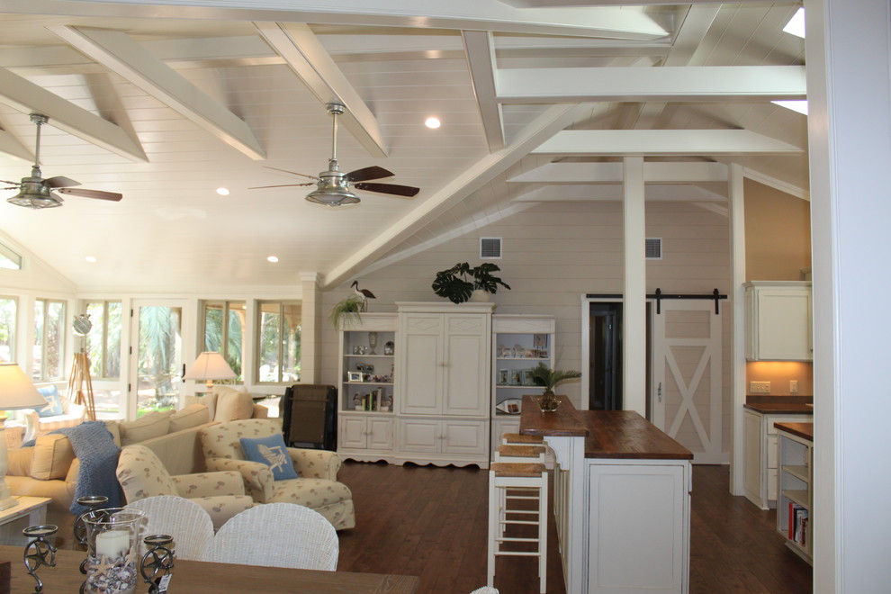 Großes, Offenes Wohnzimmer mit weißer Wandfarbe, braunem Holzboden, Kamin, Kaminumrandung aus Backstein und braunem Boden in Jacksonville
