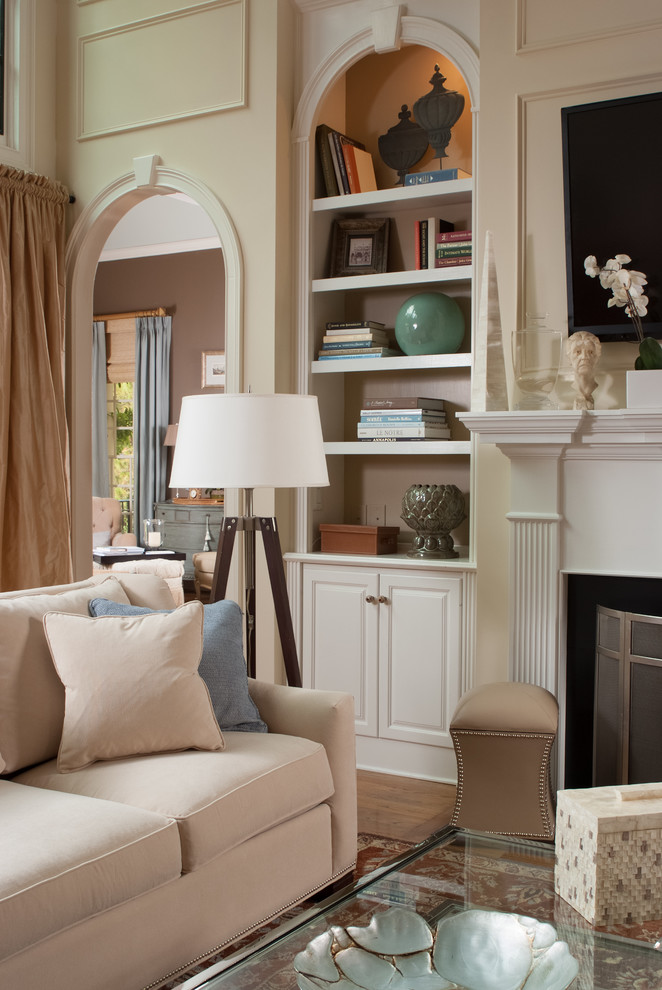 Inspiration for a medium sized traditional living room in Atlanta with beige walls, a standard fireplace, a plastered fireplace surround, a wall mounted tv, medium hardwood flooring and brown floors.