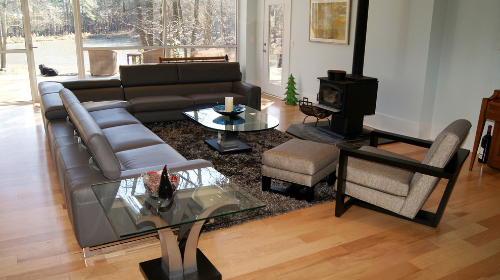 Modelo de salón para visitas abierto minimalista grande con paredes azules y suelo de madera clara