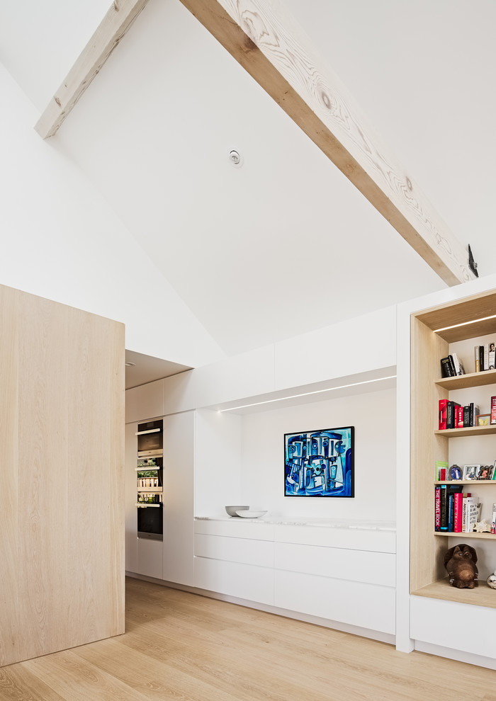 Imagen de salón para visitas abierto minimalista grande sin televisor con paredes blancas, suelo de madera clara y suelo beige