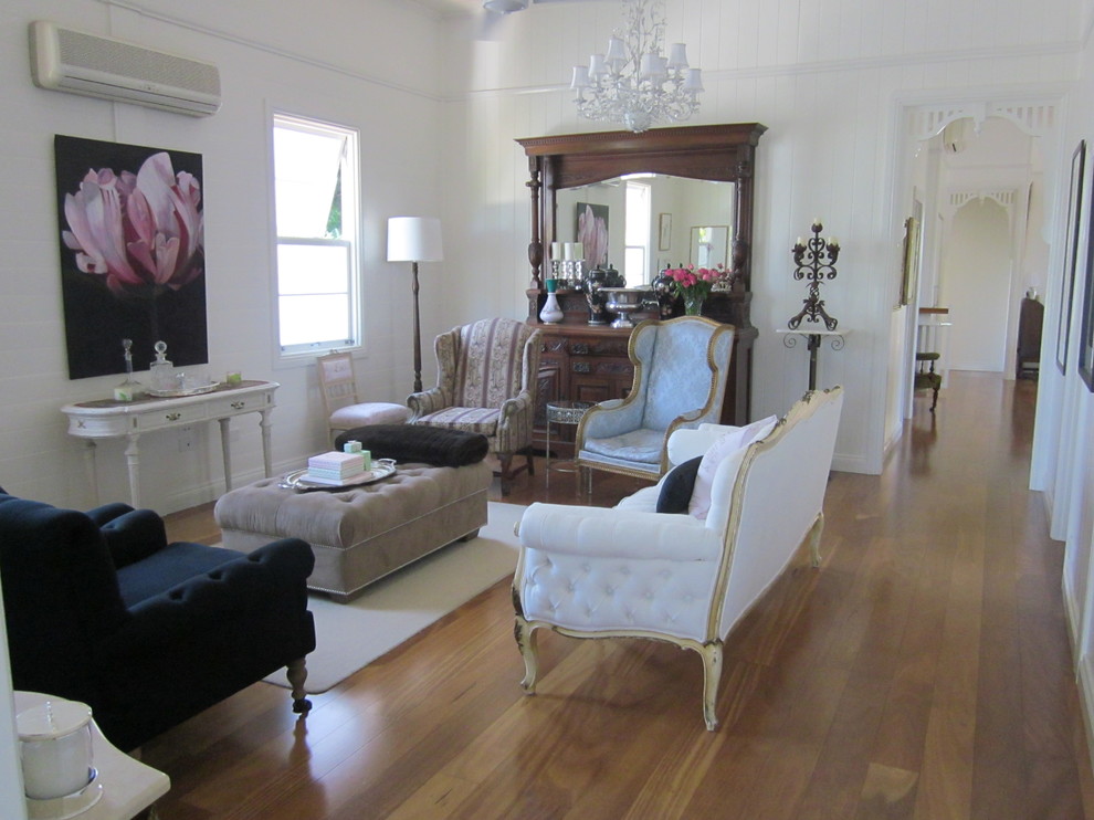 Ejemplo de salón para visitas abierto tradicional grande con paredes blancas y suelo de madera en tonos medios