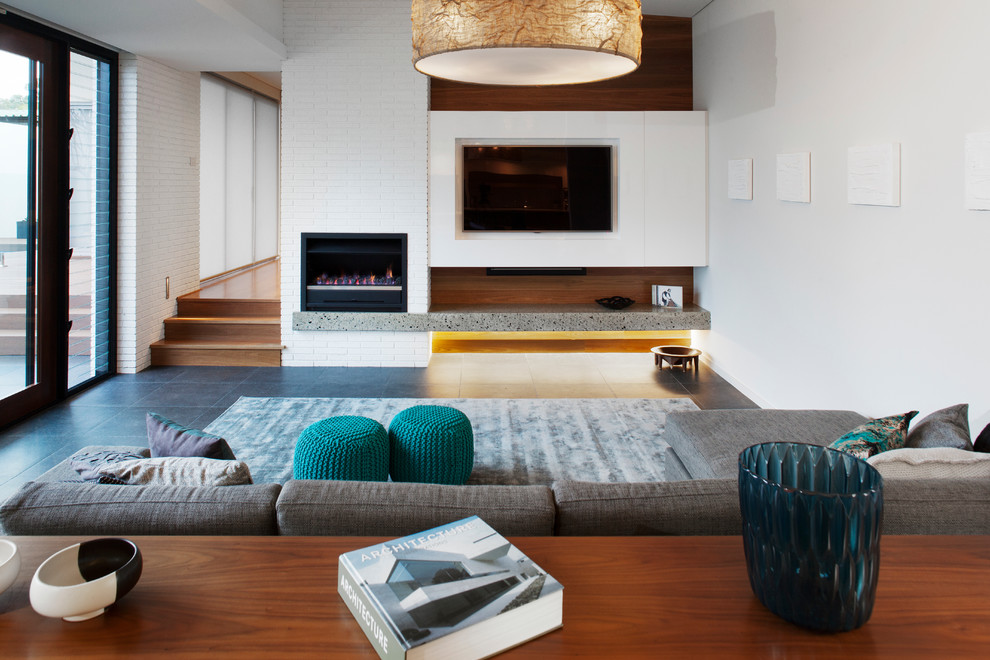 Modernes Wohnzimmer mit weißer Wandfarbe, Schieferboden, Kamin, Kaminumrandung aus Backstein und TV-Wand in Perth