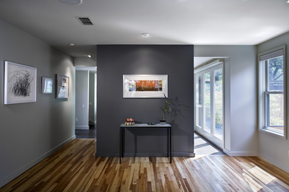 Example of a small trendy medium tone wood floor living room design in Austin with gray walls