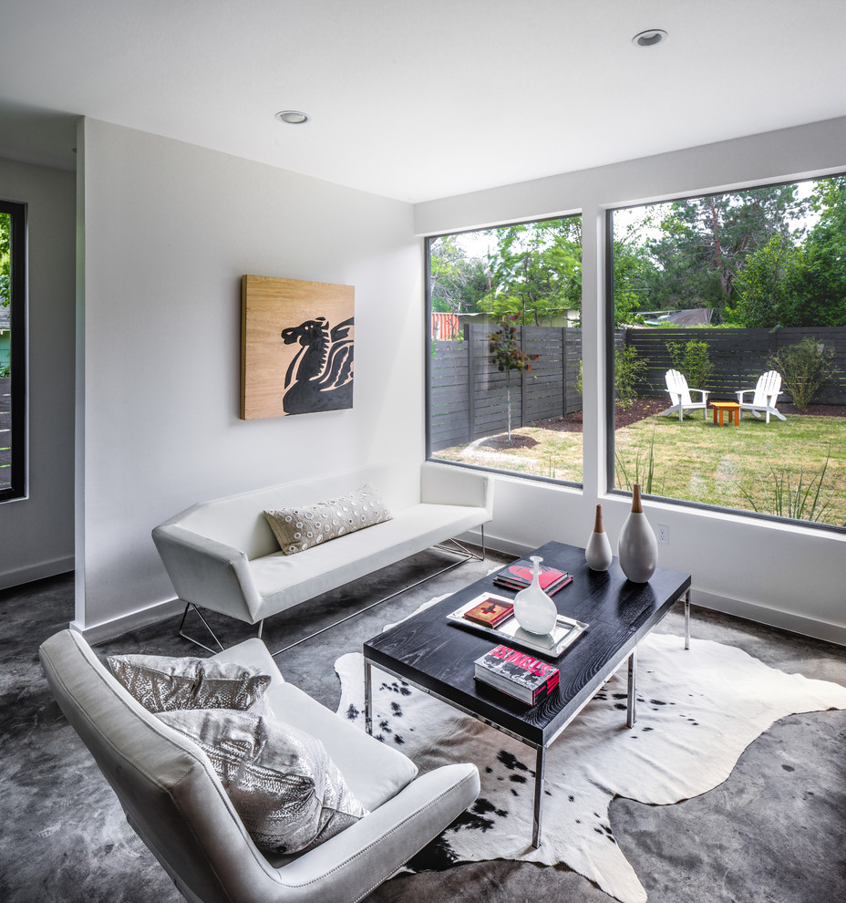Diseño de salón abierto contemporáneo grande con paredes blancas, suelo de cemento y televisor colgado en la pared