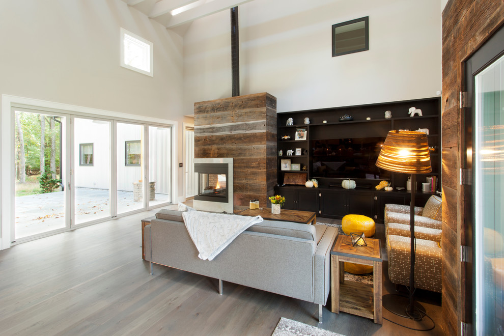 Exemple d'un salon nature de taille moyenne et ouvert avec une salle de réception, un mur blanc, parquet foncé, une cheminée double-face, un manteau de cheminée en bois, un téléviseur encastré et un sol marron.