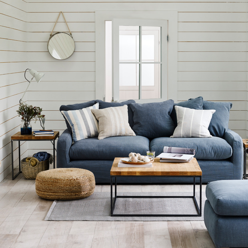 Foto di un soggiorno stile marinaro con pareti bianche, parquet chiaro e pavimento beige