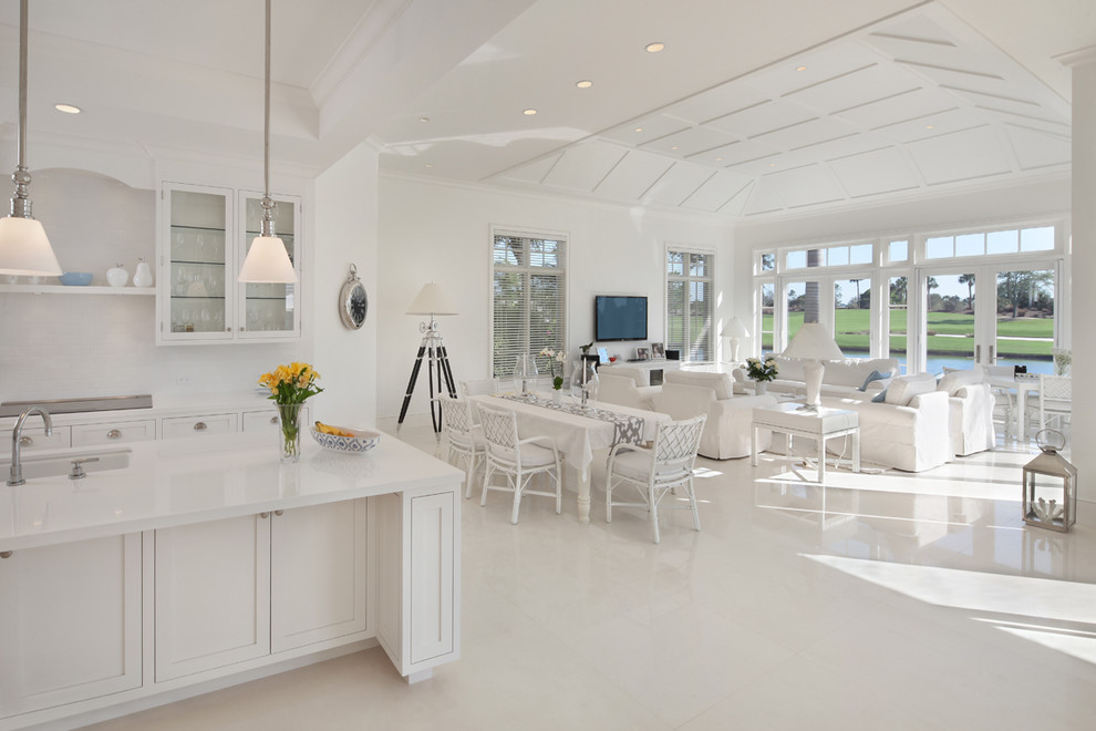 Example of an island style white floor living room design in Miami with white walls and a wall-mounted tv