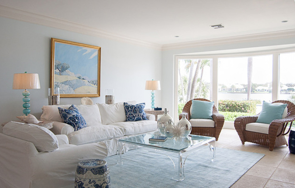 Immagine di un grande soggiorno costiero aperto con sala formale, pareti blu, pavimento in travertino, nessun camino, nessuna TV e pavimento marrone