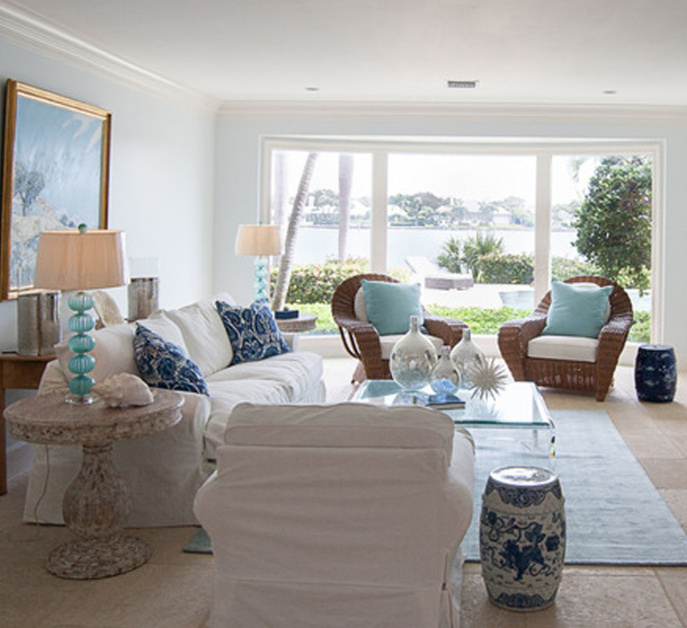Modelo de salón para visitas abierto costero grande sin chimenea y televisor con paredes azules, suelo de travertino y suelo marrón