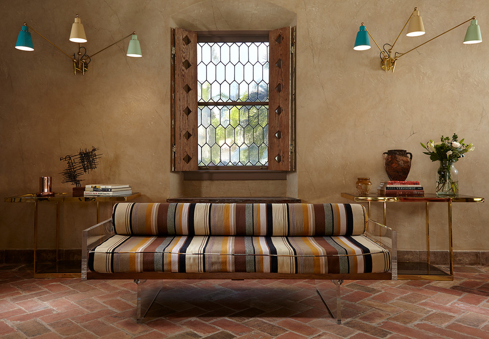 Inspiration pour un salon méditerranéen avec un mur beige, un sol en brique et un sol rouge.