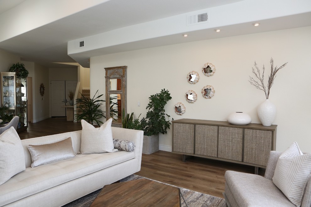 Offenes Klassisches Wohnzimmer mit beiger Wandfarbe, Vinylboden, Kaminumrandung aus Stein und braunem Boden in San Diego