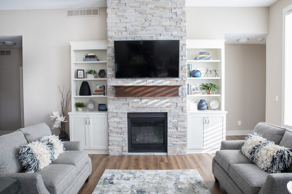 他の地域にある高級な広いトランジショナルスタイルのおしゃれなLDK (ベージュの壁、クッションフロア、標準型暖炉、石材の暖炉まわり、壁掛け型テレビ、茶色い床) の写真