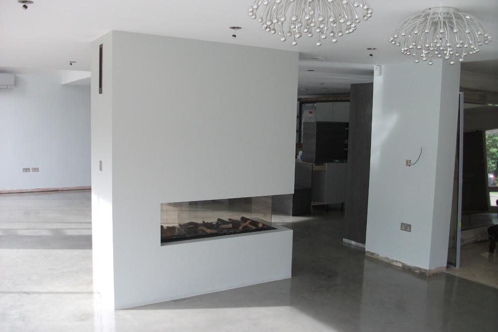 Idee per un ampio soggiorno design aperto con pareti bianche, pavimento in cemento, pavimento grigio, sala formale e nessun camino