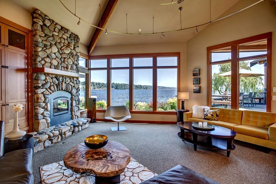 This is an example of a medium sized classic open plan living room in Seattle with beige walls, carpet, a standard fireplace, a stone fireplace surround, no tv and brown floors.