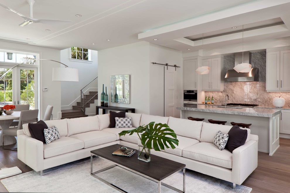 World-inspired formal open plan living room in Miami with white walls, medium hardwood flooring and no fireplace.